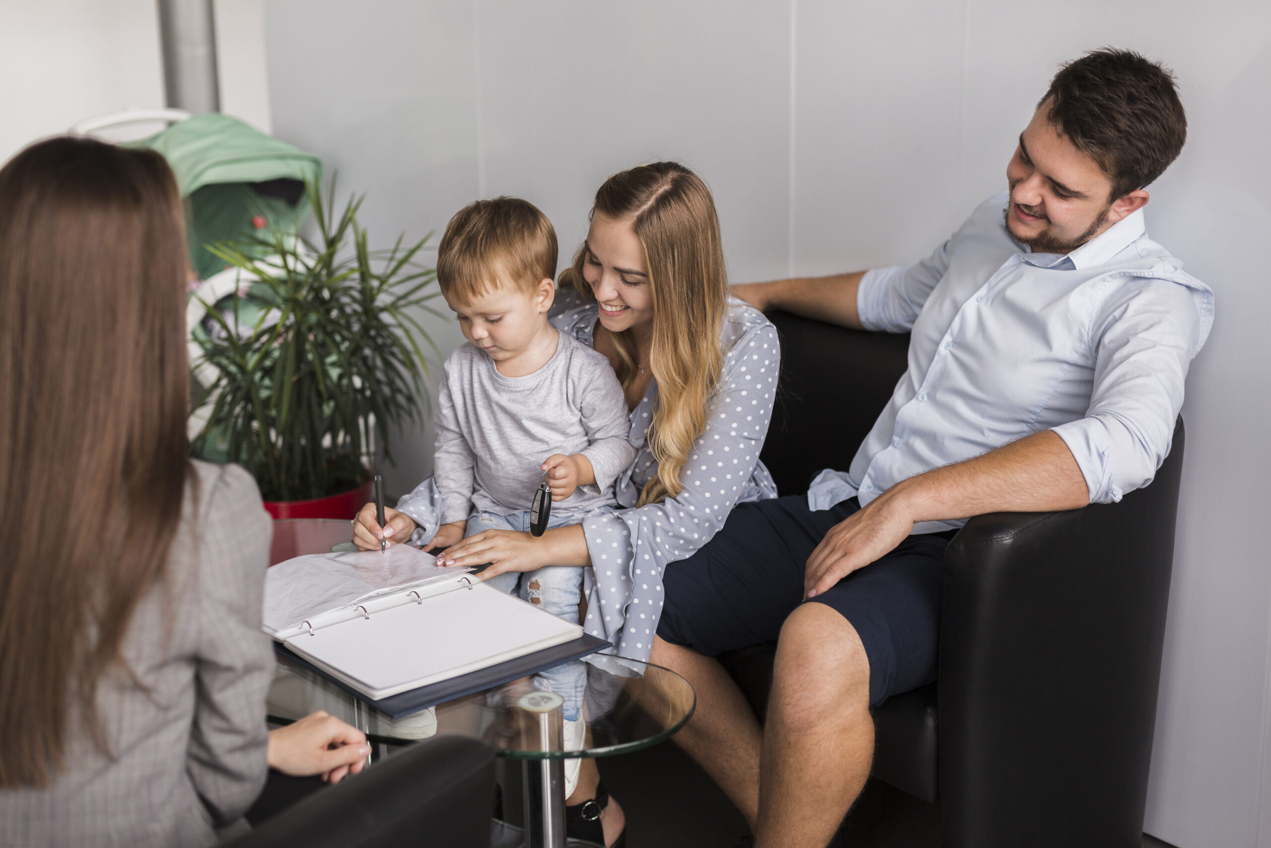 An adorable little kid is shown signing a contract with a psychologist.