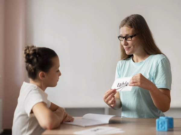 Psychologist helping a little girl with speech therapy